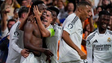 Vinícius Junior celebra con sus compañeros tras anotar el cuarto gol del Real Madrid en la victoria 5-2 ante Borussia Dortmund en la Liga de Campeones, el martes 22 de octubre de 2024, en Madrid.