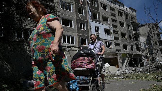 Foto de ucranianos frente a un edificio bombardeado por los rusos en la region del Donetsk.
