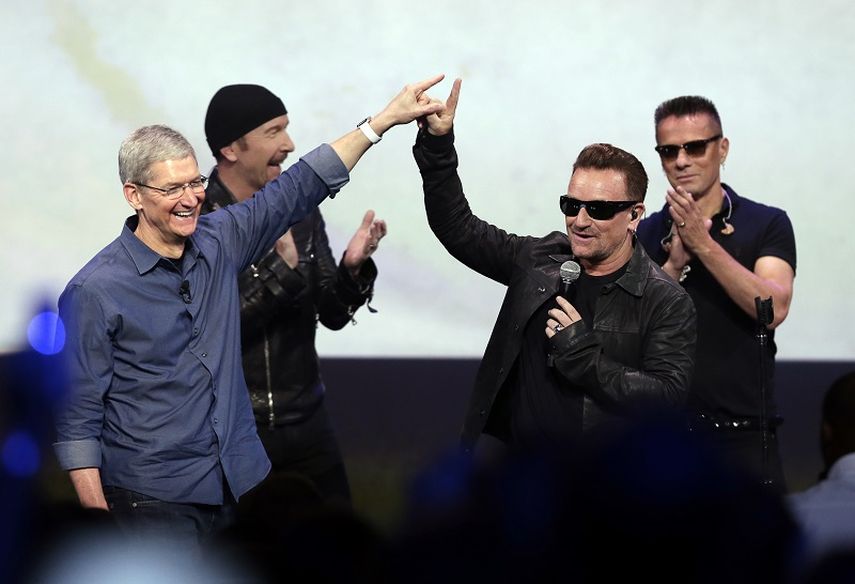 Tim Cook, presidente de Apple, saluda a Bono, de la banda U2, durante el cierre del evento de lanzamiento. (AP)