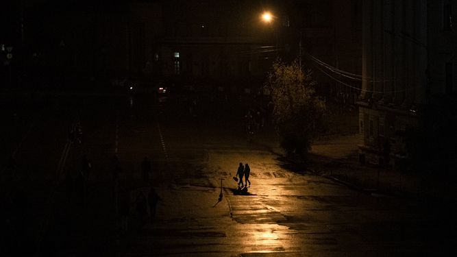Gente cruzando una calle durante un apagón en Kiev, Ucrania, el domingo 6 de noviembre de 2022.&nbsp;