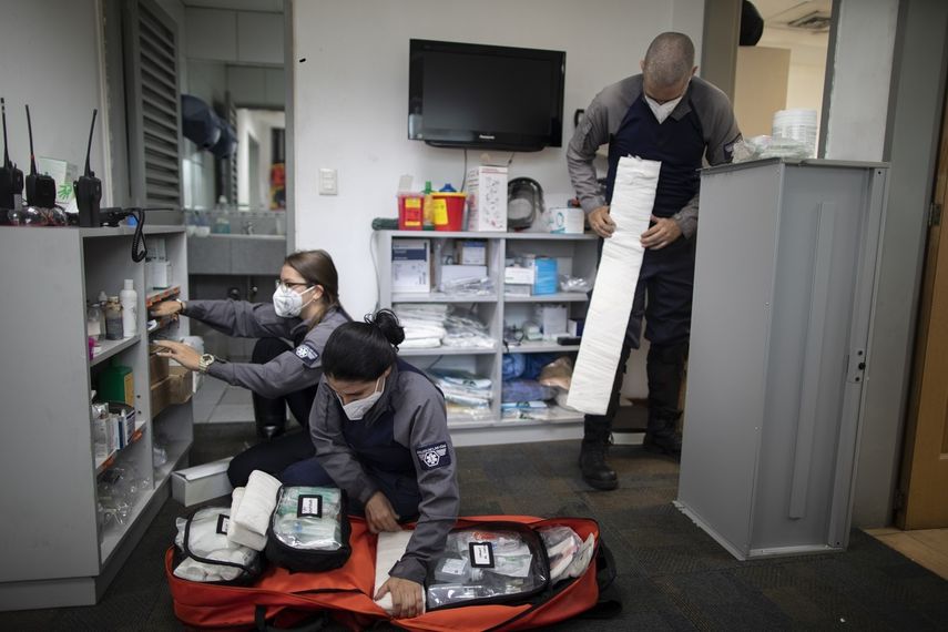 De izq. a der., los socorristas voluntarios de la organización Ángeles de las Vías Laura Lara, Zully Rodiz y Jonathan Quantip preparan el equipo para emergencias en la oficina de la agrupación el 8 de febrero del 2021 en Caracas.