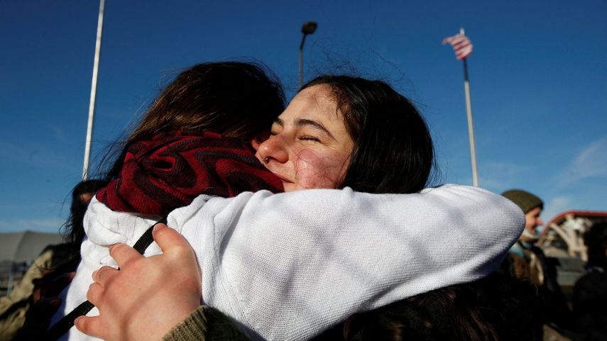 Mensaje para Trump desde la frontera: manifestantes se abrazan sobre el puente fronterizo de Ciudad Juárez.