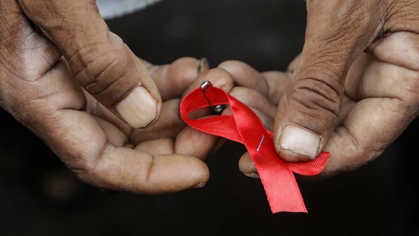 Un hombre sostiene el lazo rojo que conmemora el Día Mundial de la Lucha contra el&nbsp;Sida.&nbsp;
