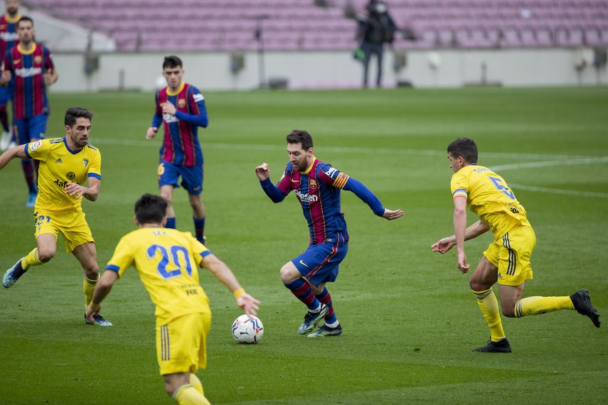Lionel Messi (centro) del Barcelona avanza con el balón durante el partido contra el Cádiz por la Liga española, el domingo 21 de febrero de 2021.&nbsp;