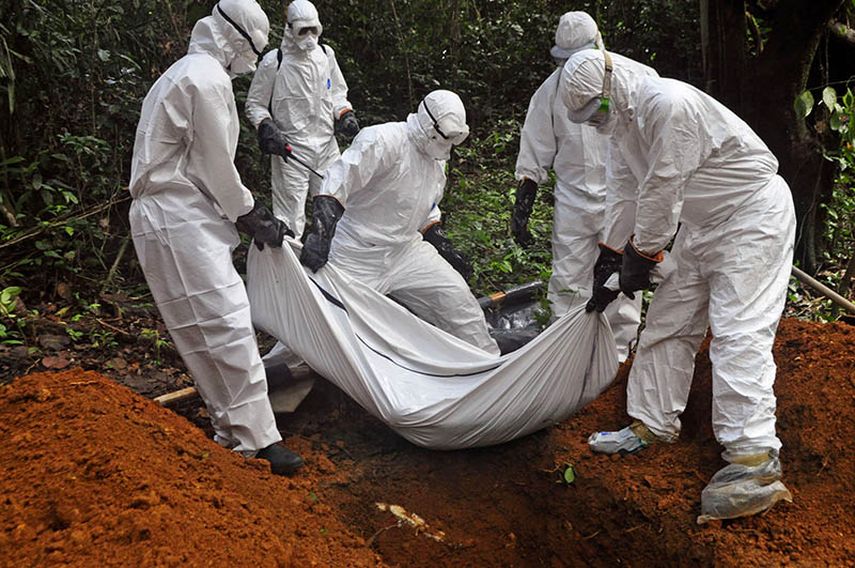 Trabajadores sanitarios entierran a una mujer fallecida presuntamente de ébola, en Monrovia, Liberia, el 10 de octubre de 2014. (AP)