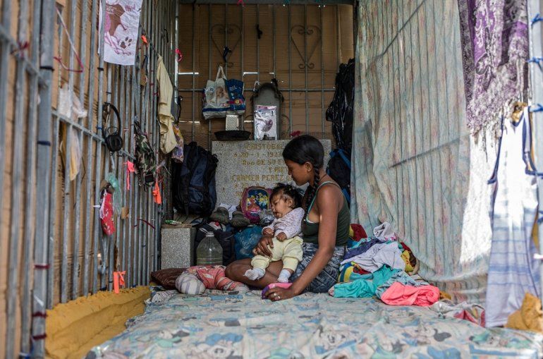 NOTICIA DE VENEZUELA  - Página 61 Una-joven-y-un-bebe-descansan-un-refugio-improvisado-el-cementerio-general-del-sur-caracas-el-16-febrero-2021-las-tumbas-profanadas-se-han-convertido-el-hogar-muchas-personas-hogar-venezuela-