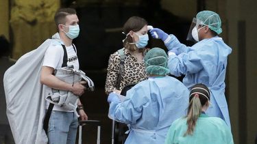 Personal sanitario toma la temperatura a una hu&eacute;sped a la salida de un hotel en Espa&ntilde;a.