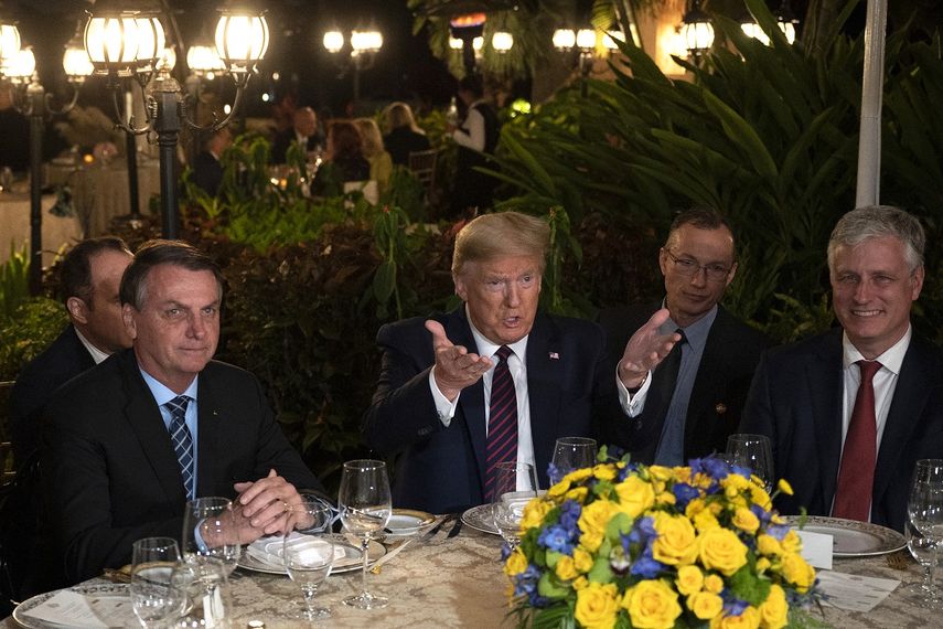 El presidente Donald Trump, al centro, acompa&ntilde;ado por su hom&oacute;logo brasile&ntilde;o, Jair Bolsonaro (izq), y por el asesor de Seguridad Nacional&nbsp;Robert OBrien, dufrante una cena en Mar-a-Lago, Palm Beach, Florida, el s&aacute;bado 7 de marzo de 2020.