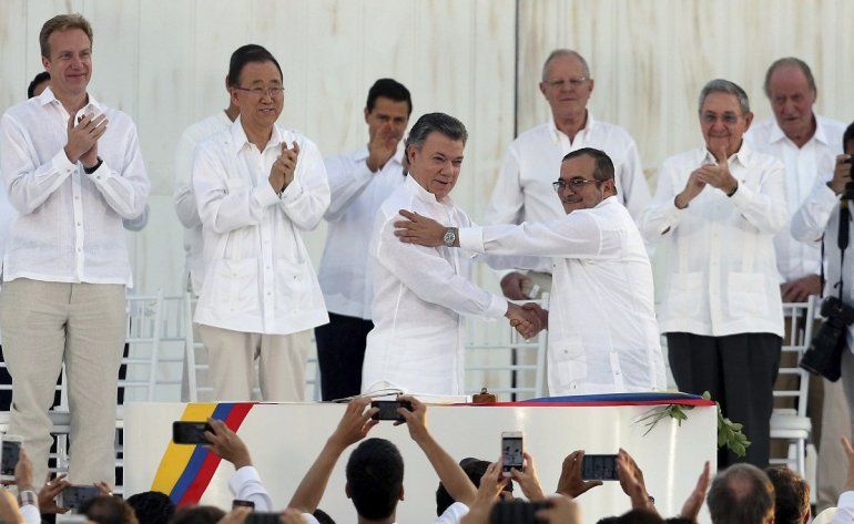 En esta foto de archivo del 26 de septiembre de 2016, el presidente colombiano Juan Manuel Santos, al frente a la izquierda, y el máximo comandante de las Fuerzas Armadas Revolucionarias de Colombia (FARC), Rodrigo Londoño alias 