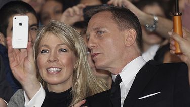 Daniel Craig mientras se toma una foto con una fan. (AP)