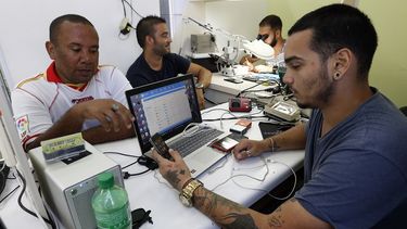 Dos personas acuden a un negocio privado de reparación de teléfonos celulares en La Habana, Cuba. 