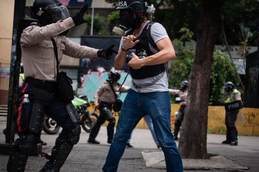 Un Policía Nacional Bolivariano frente a un periodista venezolano.&nbsp;