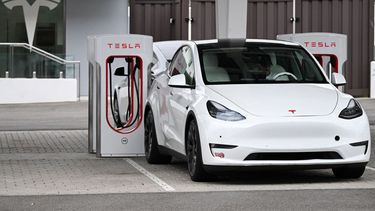 Un auto Tesla recarga sus baterías en una estación.