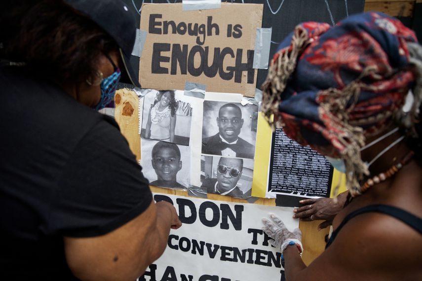 Wendy Long, izquierda, y Sister Mamie colocan carteles que fueron arrancados de la barda peimetral del parque Lafayette durante las protestas, mi&eacute;rcoles 10 de junio de 2020.&nbsp;