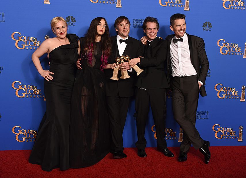 El elenco de Boyhood posa junto al director Richard Linklater, quien sostiene los trofeos. (AP)