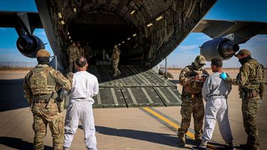 Miembros del Ejército montan en un avión militar a inmigrantes convictos.