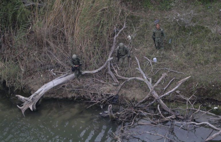 Militares mexicanos observan un cadáver flotando en el agua y que fue descubierto por agentes fronterizos estadounidenses mientras patrullaban desde el aire la zona del río que divide la frontera entre México y Texas.