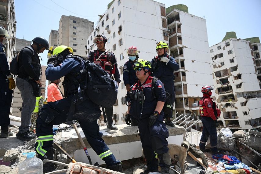 Miembros del equipo de búsqueda y rescate USAR de Chile permanecen sobre los escombros de edificios dañados en Catia La Mar, La Guaira, Venezuela, el 26 de junio de 2026, tras los devastadores terremotos. &nbsp;