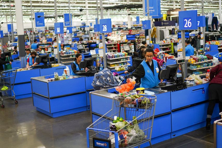 Empleadas de la cadena Walmart atienden a clientes.