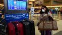 Una mujer en el aeropuerto de Los Angeles usa una mascarilla mientras busca información en la pantalla sobre su vuelo. Una mujer en el aeropuerto de Los Angeles usa una mascarilla mientras busca información en la pantalla sobre su vuelo.