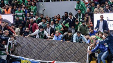 Varios fanáticos intentan despejar el área luego de un derrumbe de gradas durante un partido de baloncesto en El Cairo.