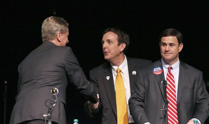 Los candidatos republicanos a gobernador de Arizona Andrew Thomas y Ken Bennett se saludan, y junto a ellos está Doug Ducey (Foto AP)