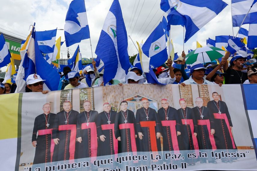 Manifestantes contra el gobierno llevan un cartel que representa a un grupo de cardenales católicos, entre ellos, el nicaragüense Leopoldo Brenes, en el centro a la derecha, y con una frase del papa Juan Pablo II a favor de la paz, en una marcha de apoyo a la Iglesia católica, en Managua, Nicaragua, el 28 de julio de 2018. 