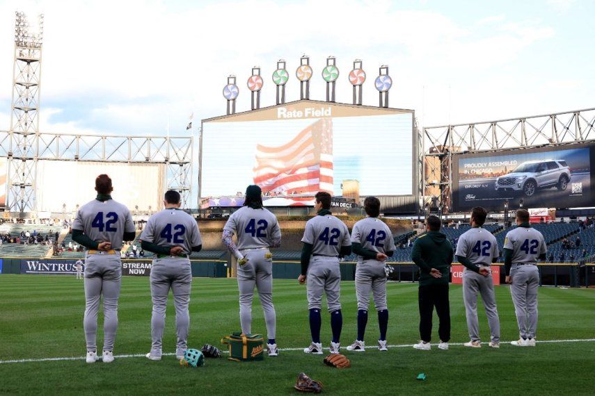 Los Atléticos de Oakland juegan en pie durante el himno nacional antes del partido contra los Medias Blancas de Chicago en el Rate Field el 15 de abril de 2025 en Chicago, Illinois. Todos los jugadores llevan el número 42 en honor al Día de Jackie Robinson de la MLB&nbsp;