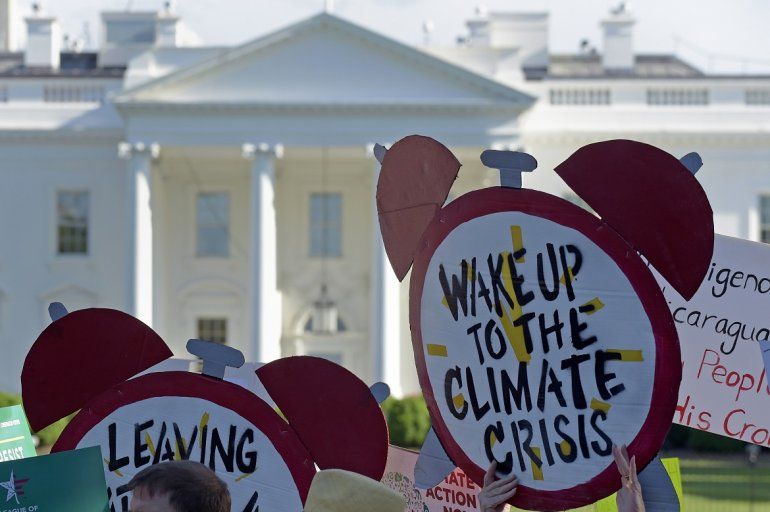 En esta imagen del 1 de junio de 2017, manifestantes reunidos ante la Casa Blanca para protestar por la decisión del presidente de Estados Unidos, Donald Trump, de retirar al país del Acuerdo Climático de París. 
