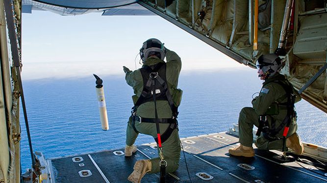 Tripulantes de un avión de la fuerza aérea australiana tiran al mar boyas que permiten estudiar las corrientes marinas, dato que podría ayudar a encontrar el avión malayo desaparecido sobre el Océano Índico. (AP Photo/Australian Defence Department, Jus
