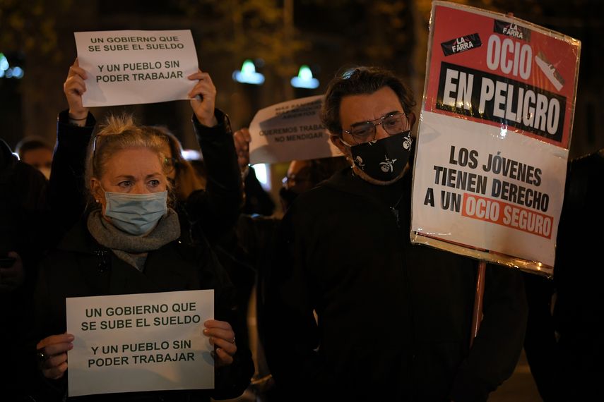 Manifestantes en Barcelona, España, sostienen carteles durante una manifestación contra las nuevas restricciones del coronavirus.