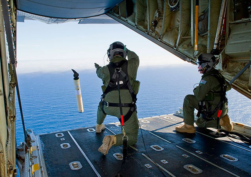 Tripulantes de un avión de la fuerza aérea australiana tiran al mar boyas que permiten estudiar las corrientes marinas, dato que podría ayudar a encontrar el avión malayo desaparecido sobre el Océano Índico. (AP Photo/Australian Defence Department, Jus