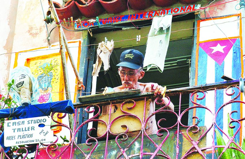 Un anciano dibuja en un balcón de Centro Habana. (EFE)