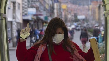 Una mujer camina a trav&eacute;s de un t&uacute;nel que roc&iacute;a desinfectante durante la cuarentena que restringe a los residentes a realizar compras esenciales por las ma&ntilde;anas en un intento por contener la propagaci&oacute;n del nuevo coronavirus en La Paz, Bolivia, el lunes 4 de mayo de 2020.&nbsp;