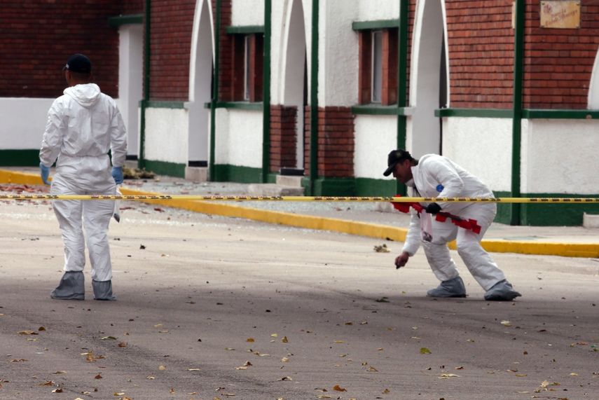 - Peritos forenses inspeccionan el lugar donde un carro bomba causó una explosión este jueves en la Escuela General Santander de la Policía en Bogotá (Colombia).