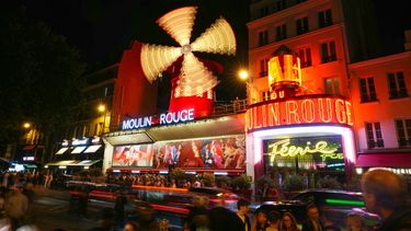 Esta fotografía de larga exposición muestra las nuevas aspas del Molino de Viento del Moulin Rouge girando mientras el cabaret celebra su regreso a París el 10 de julio de 2025. &nbsp;