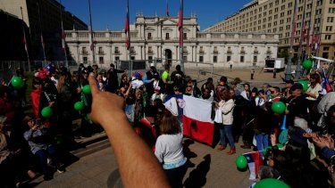 La gente participa en una manifestación pidiendo justicia para los policías asesinados en el cumplimiento de su deber, frente al palacio presidencial de La Moneda en Santiago, Chile, el sábado 27 de abril de 2024.