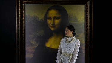 Una mujer posa para fotografías junto a una reproducción del retrato de Lisa Gherardini, esposa de Francesco del Giocondo, conocida como la Mona Lisa o La Gioconda, durante la exposición Da Vinci Experience en la Ciudad de México, el 10 de junio de 2021.&nbsp;