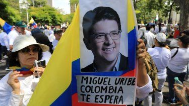 Una mujer sostiene una bandera nacional durante la llamada Marcha Silenciosa para mostrar apoyo a la salud del senador Miguel Uribe Turbay y pedir paz para el país en Medellín, Colombia, el 15 de junio de 2025.