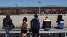 Migrantes observan a otros junto al muro fronterizo en Ciudad Juárez, México, el miércoles 21 de diciembre de 2022.