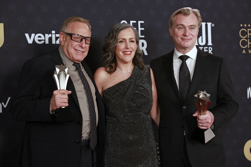 De izquierda a derecha: el productor estadounidense Charles Roven, la productora británica Emma Thomas y el director británico Christopher Nolan, ganadores del premio a la Mejor película por Oppenheimer, posan en la sala de prensa durante la 29ª edición de los Critics Choice Awards en el Barker Hangar de Santa Mónica, California, el 14 de enero de 2024.