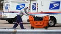 Un empleado del Servicio Postal traslada unos paquetes frente a una oficina en Wheeling, Illinois.  