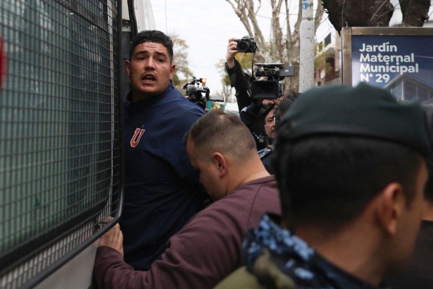 Un hincha de la Universidad de Chile detenido es trasladado por la Policía de la Provincia de Buenos Aires desde una comisaría en Avellaneda, provincia de Buenos Aires, Argentina, el 21 de agosto de 2025. Unas 20 personas resultaron heridas y más de 100 fueron detenidas, informaron las autoridades el jueves, tras la suspensión de un partido de la Copa Sudamericana en Buenos Aires entre Independiente y la Universidad de Chile, que se jugó de visitante, tras la violencia sostenida de la multitud.&nbsp;