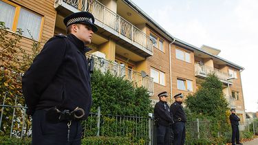 Policías montan guardia afuera de una unidad de departamentos durante las investigaciones casa por casa en una zona donde tres mujeres fueron mantenidas supuestamente como esclavas durante 30 años en una vivienda en el sur de Londres. (AP Fhoto/Dominic