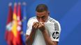 El delantero francés Kylian Mbappé besa su camiseta durante su primera aparición como jugador del Real Madrid en el Estadio Santiago Bernabéu de Madrid el 16 de julio de 2024