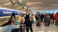 Viajeros frente al buró de reservas y procesamientos de boletos de Southwest Airlines.