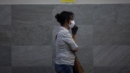Una mujer usa una mascarilla mientras camina frente a un centro de salud en Santo Domingo, Rep&uacute;blica Dominicana, el 30 de marzo de 2020.