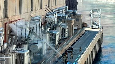 En esta imagen proporcionada por la Oficina de Recuperación de Estados Unidos, los bomberos extinguen un incendio en la presa Hoover que limita con Nevada y Arizona el martes 19 de julio de 2022, cerca de Boulder City, Nev.