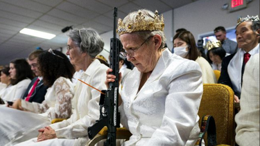 &nbsp;Una anciana realiza una oración por las armas, mientras carga su AR-15.