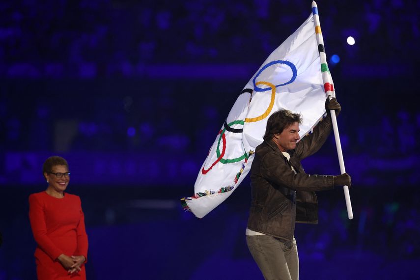 El actor estadounidense Tom Cruise sale con la bandera olímpica frente a la alcaldesa de Los Ángeles, Karen Bass, y a la gimnasta estadounidense Simone Biles, durante la ceremonia de clausura de los Juegos Olímpicos de París 2024 en el Stade de France, en Saint-Denis, en las afueras de París, el 11 de agosto.
